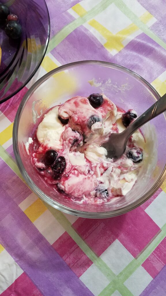 mushy blueberries partially mixed with cream cheese