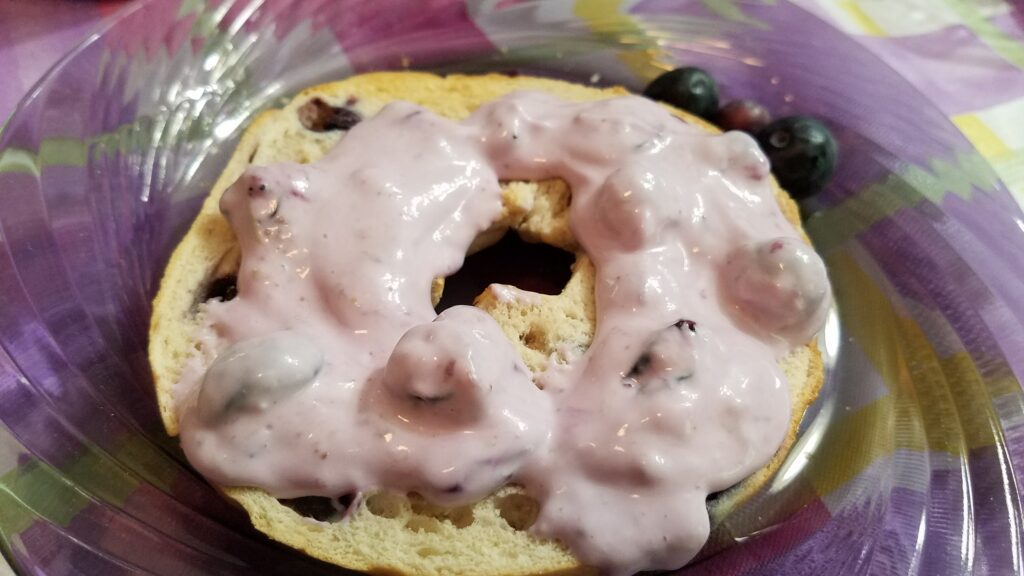 closeup of blueberry cream cheese on a bagel