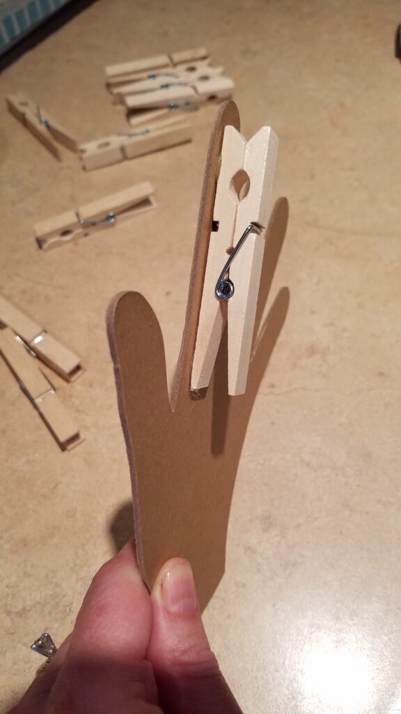 one clothespin glued to the chipboard hand