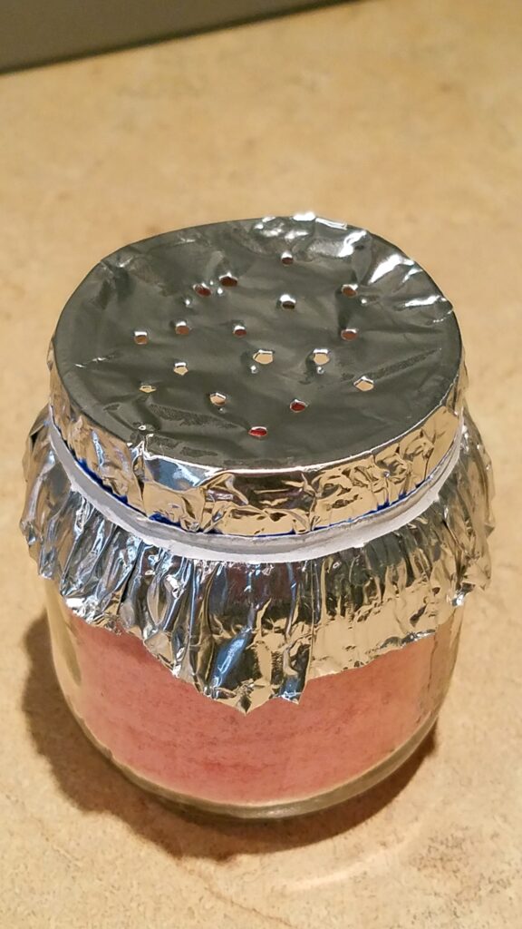 foil on a jar with holes poked in it