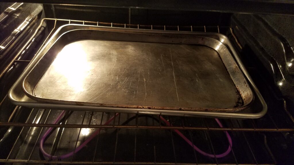 two cookie sheets on top of each other in the oven