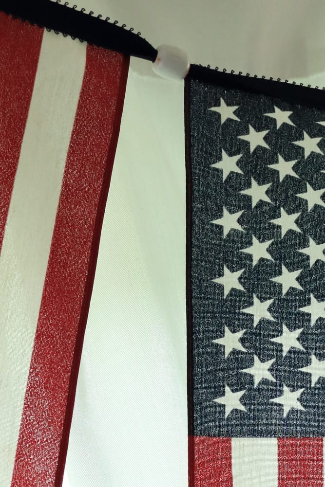 closeup of white wooden bead between flags