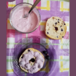 bowl of blueberry cream cheese spread with a plain bagel slice, and another bagel slice that has the cream cheese spread on it
