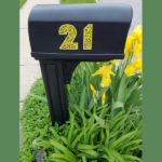 black mailbox with custom yellow numbers on it