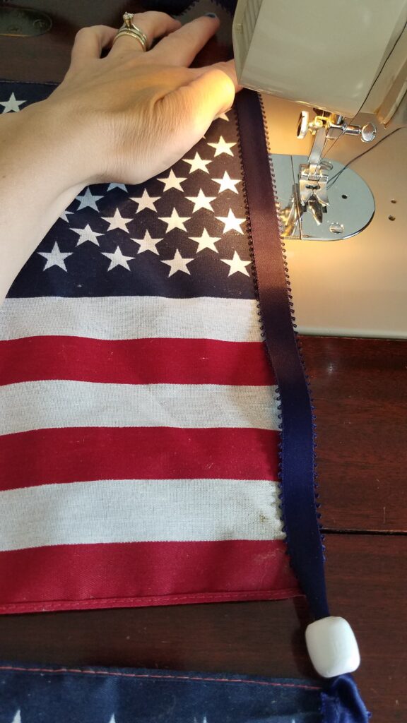 navy ribbon and flag at sewing machine ready to sew