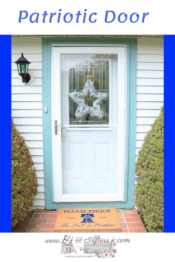 white door with green trim and white star wreath with blue accents and Liberty Bell doormat