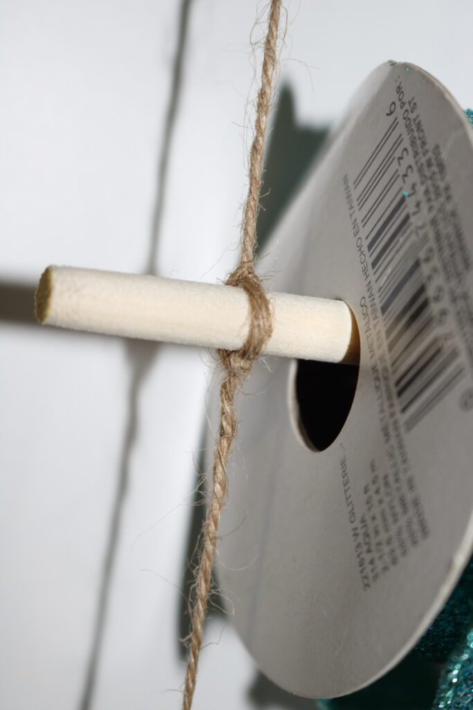 closeup of end of dowel rod with jute rope tied onto it