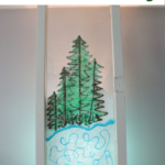 Winter Scene Window Painting of evergreen trees and pond