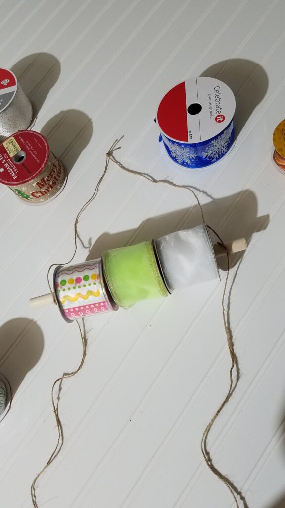 Ribbon spools on a dowel rod with jute rope