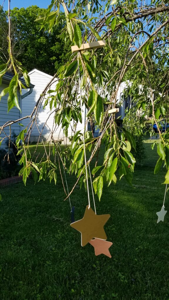 clothespins holding paper moons and stars to a tree