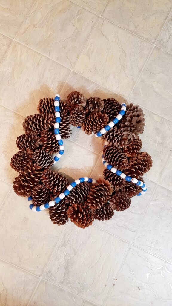 blue and white wood bead garland on pine cone wreath