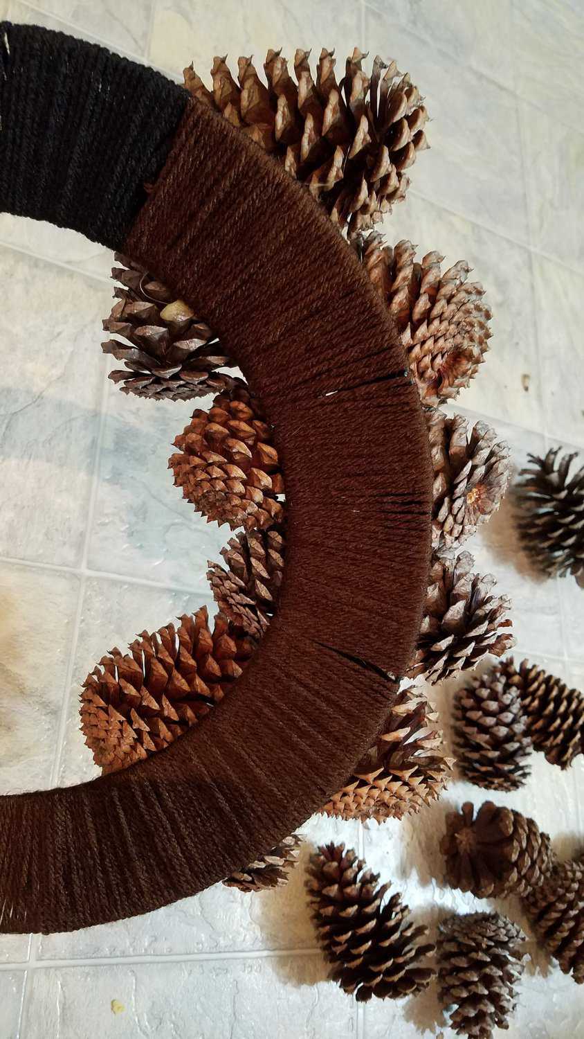 back of yarn wrapped pine cone wreath