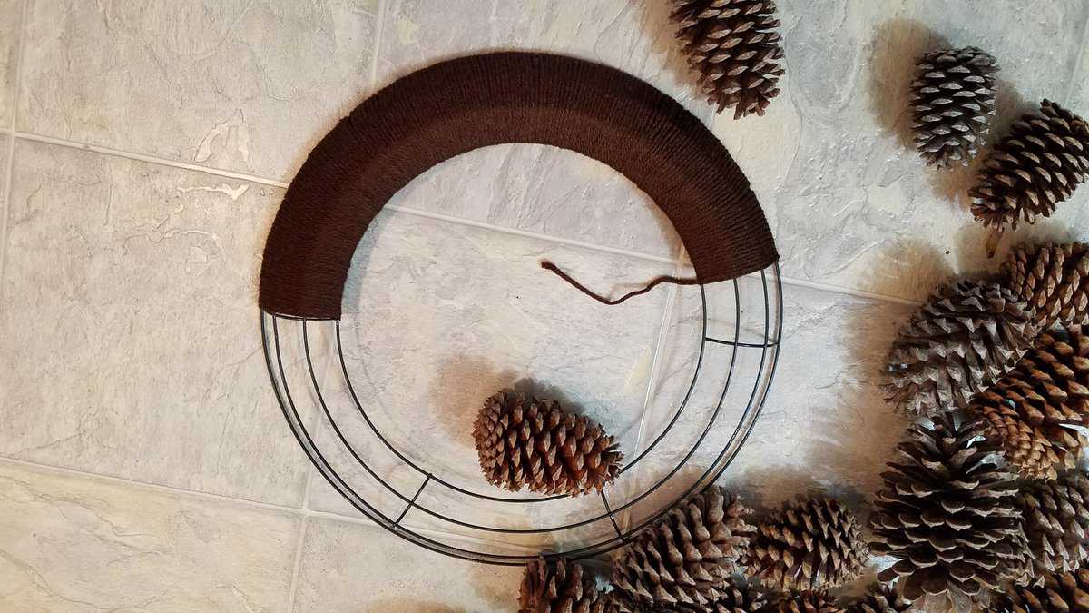 wire wreath frame half wrapped with yarn