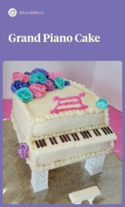 white grand piano cake with pink, purple, and teal flowers
