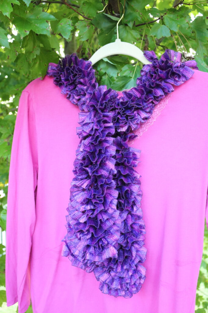 purple and pink scarf tied on a pink shirt