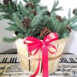 Evergreen Christmas basket with red ribbon and pine cones