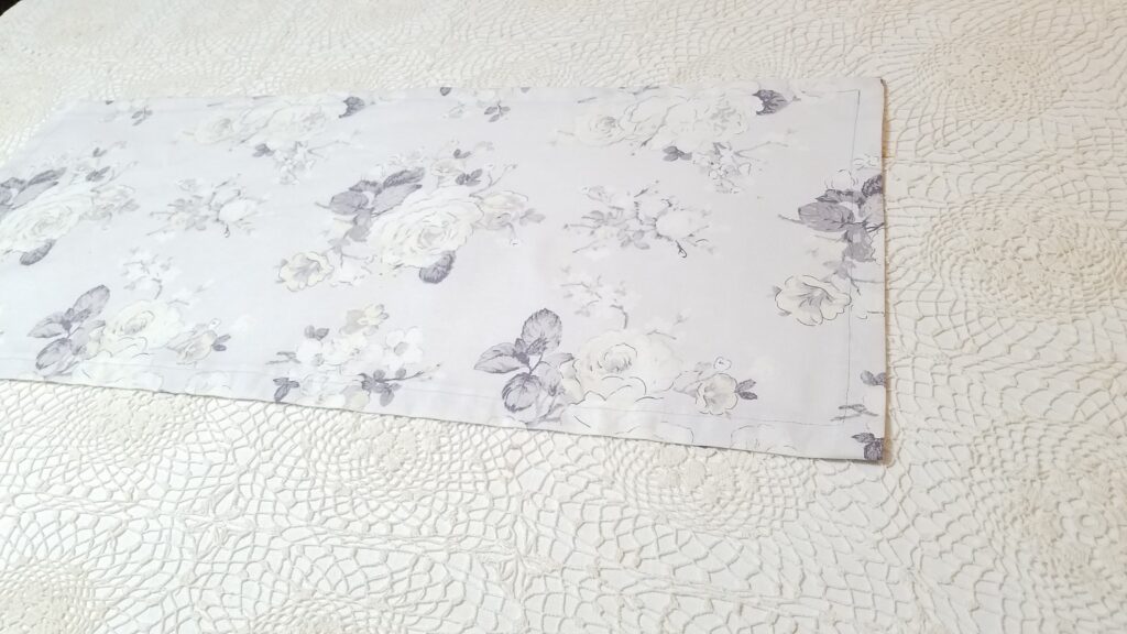 gray floral table runner over a crochet tablecloth