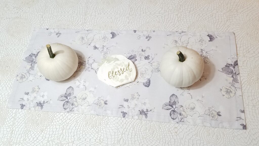 two white pumpkins with white pumpkin napkin that says blessed