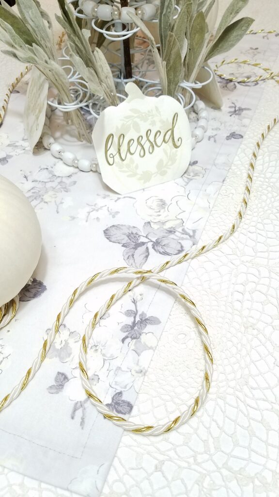 gold and white cord with white pumpkin napkin that says blessed