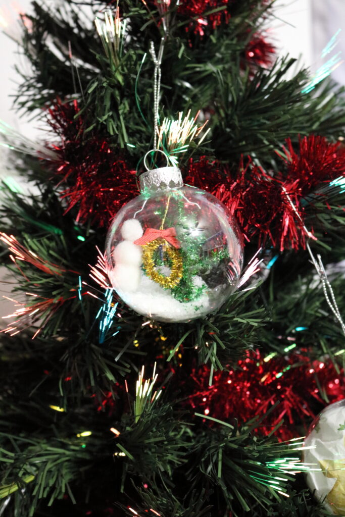 clear christmas ornament idea winter scene with snowman, tree, and wreath