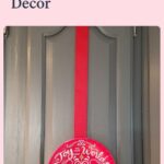 Joy to the World red paper plate on a red ribbon on a gray cabinet door