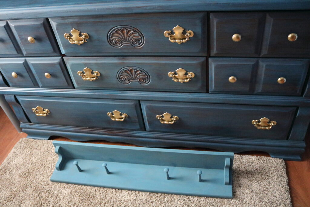 blue dresser with wall shelf in front