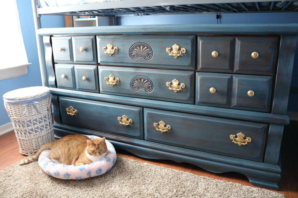 Finished blue dresser with a cat and a white basket