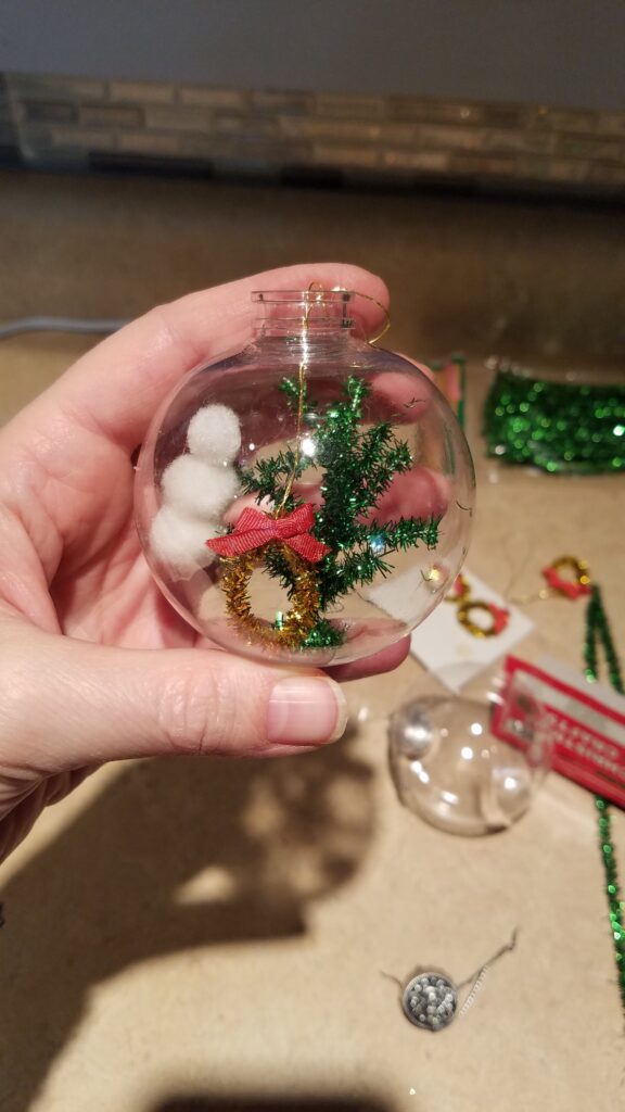 miniature snowman, tree, and wreath in a clear ornament idea