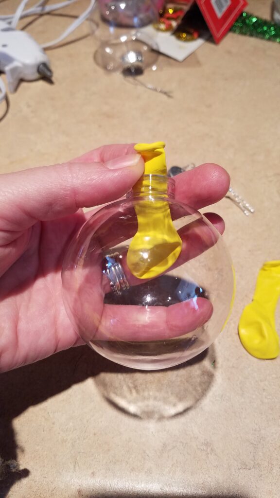 yellow balloon in a clear Christmas ornament