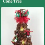 miniature pine cone tree decorated with miniature Christmas ornaments and a cute ribbon topper