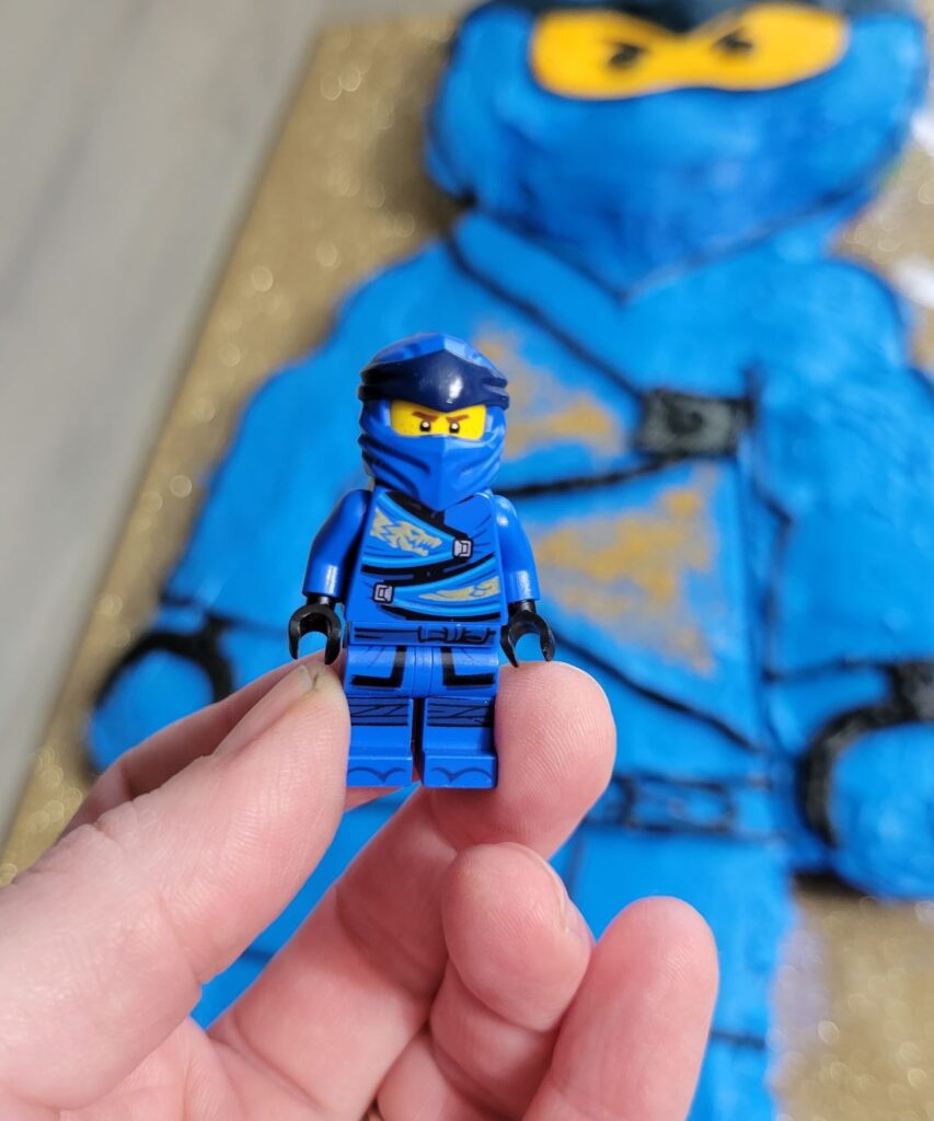 blue minifig with cake in background