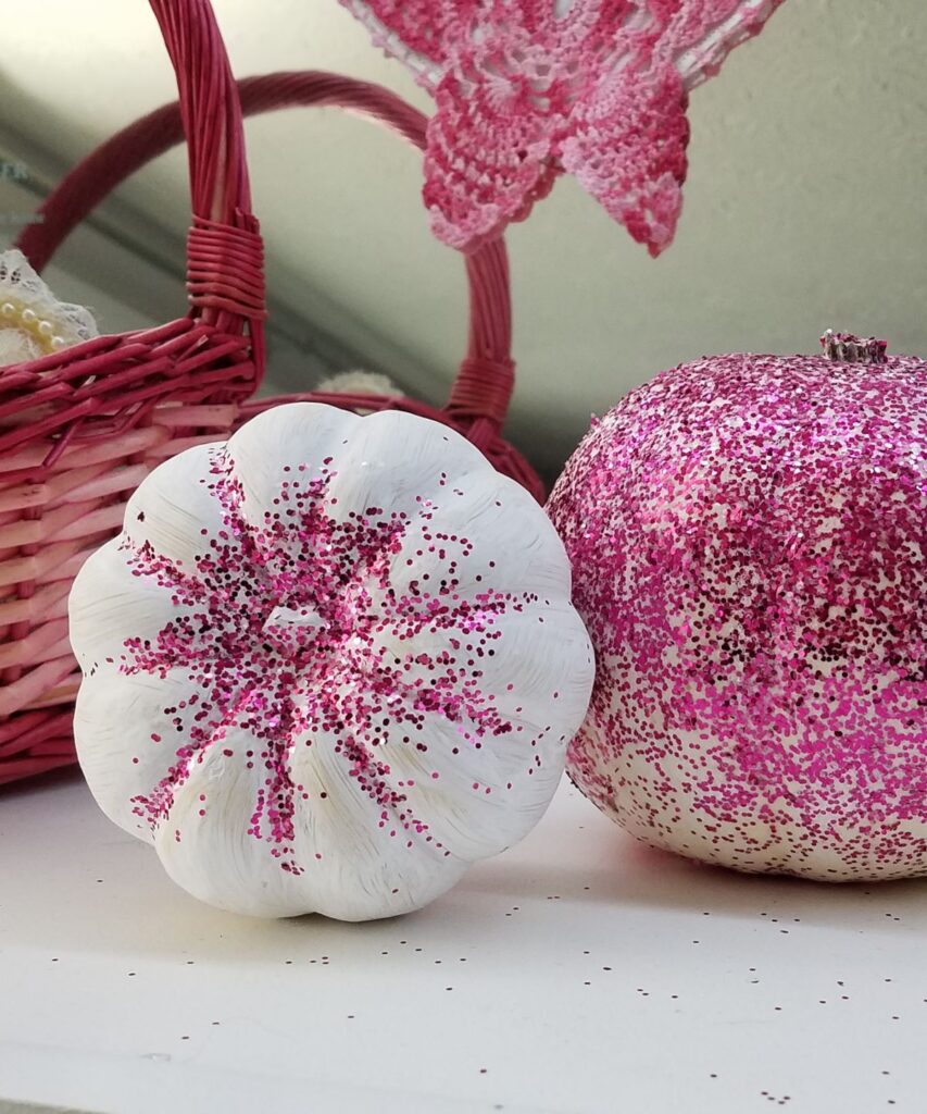 white pumpkins with pink glitter on them