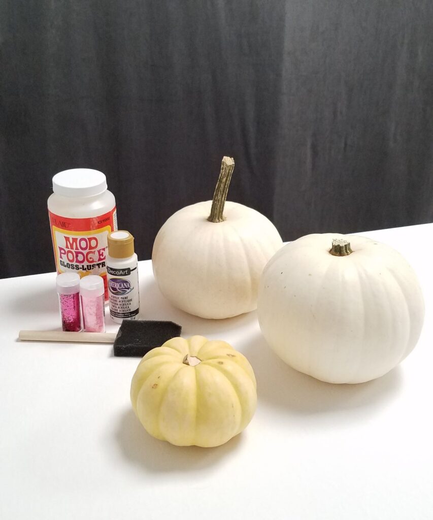 3 white pumpkins with mod podge, glitter, paint, foam brush