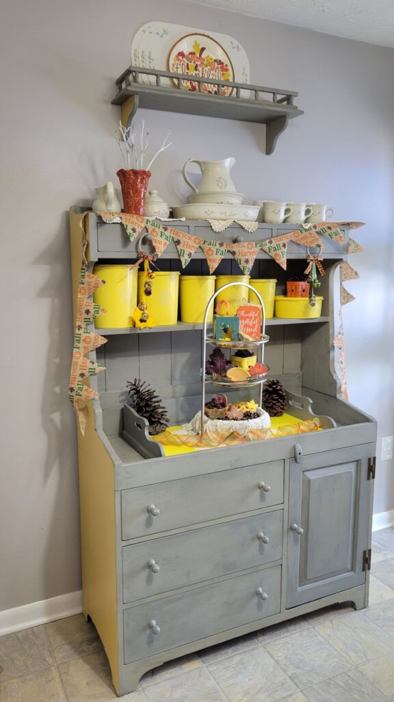 fall decorated hutch with yellow canisters