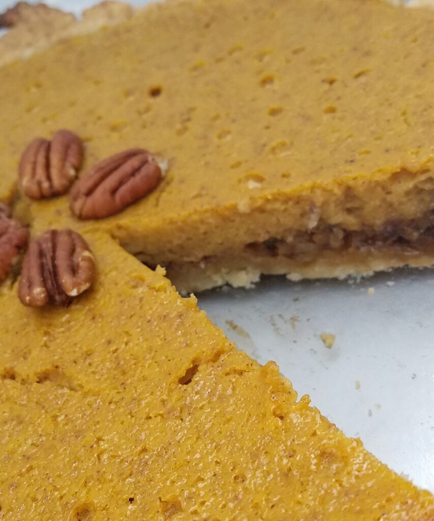 pumpkin pie with slice out of it