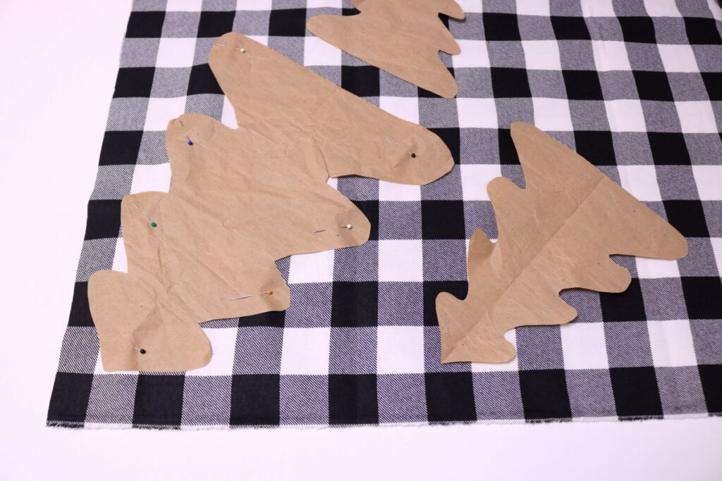 cutting out black and white buffalo plaid tree shapes