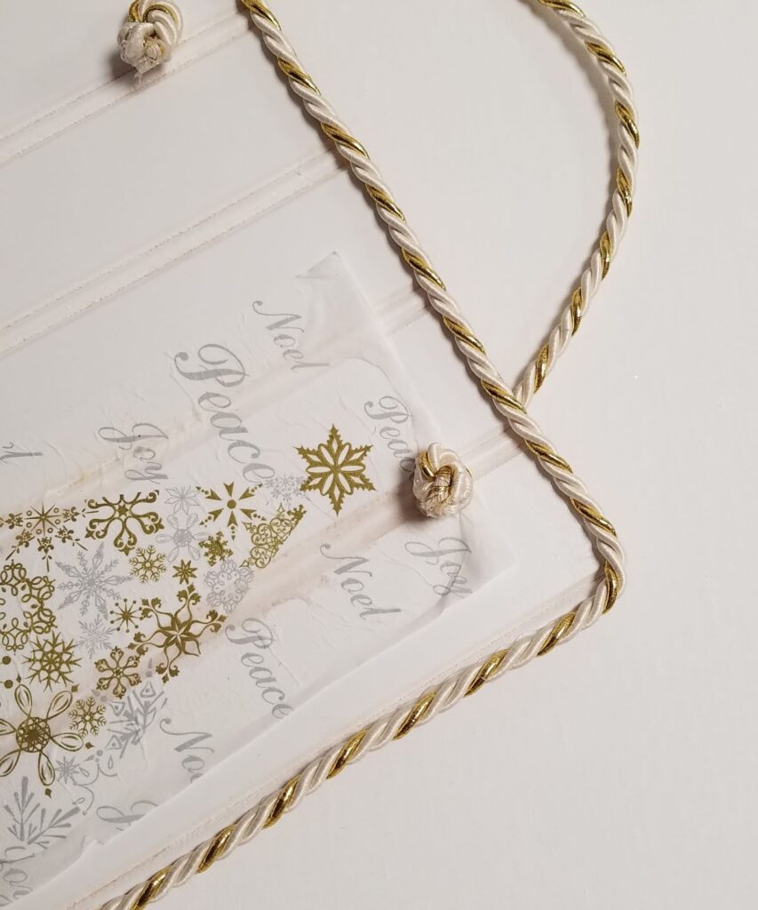 gold and white napkin and cord on sign