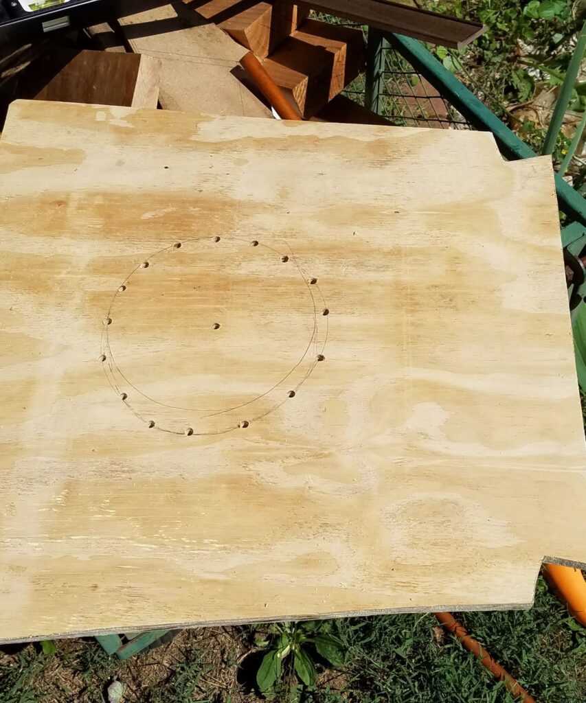 drilled holes in a circle in a piece of wood