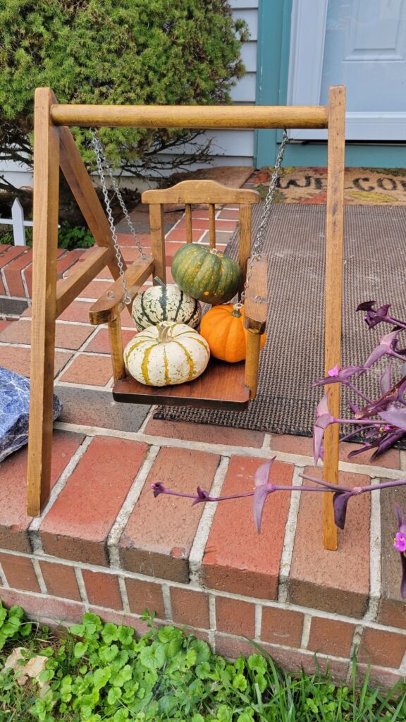 mini pumpkins on a miniature swing