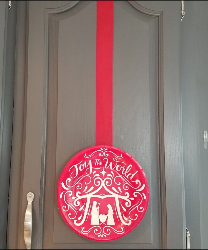 red and white paper plate for Christmas on door with red ribbon