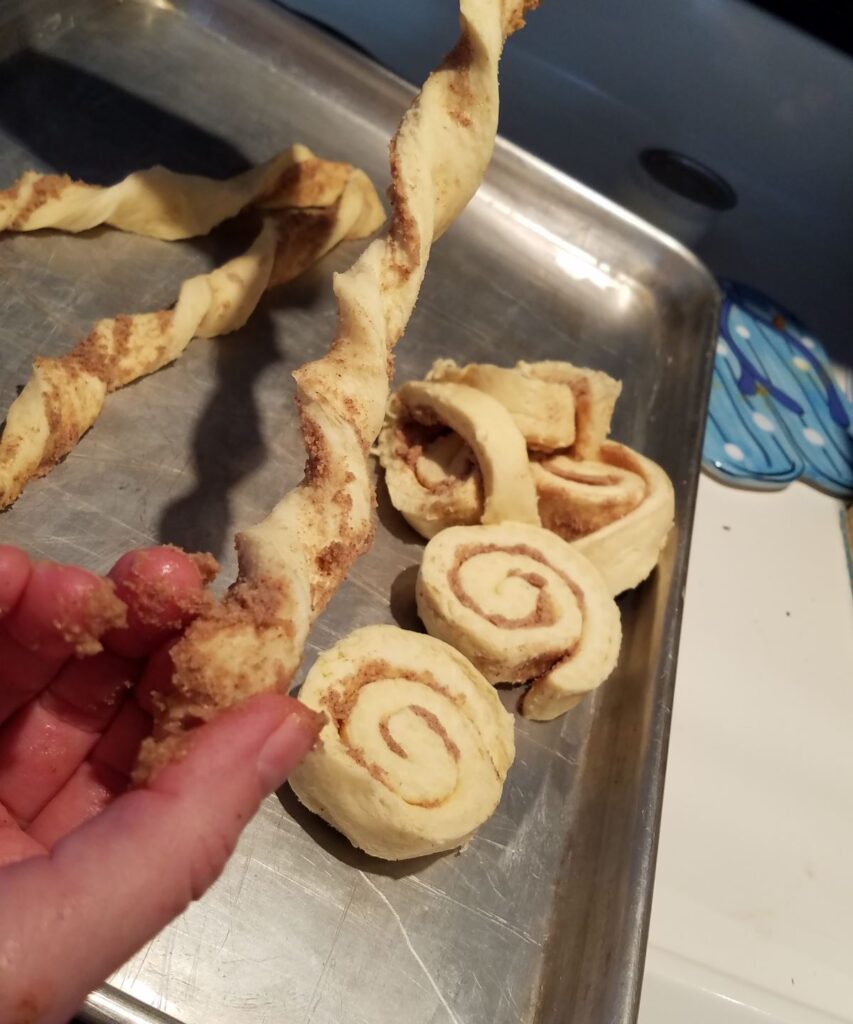 twisting a cinnamon roll strip