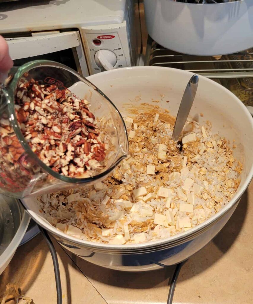 pouring pecans into cookie dough