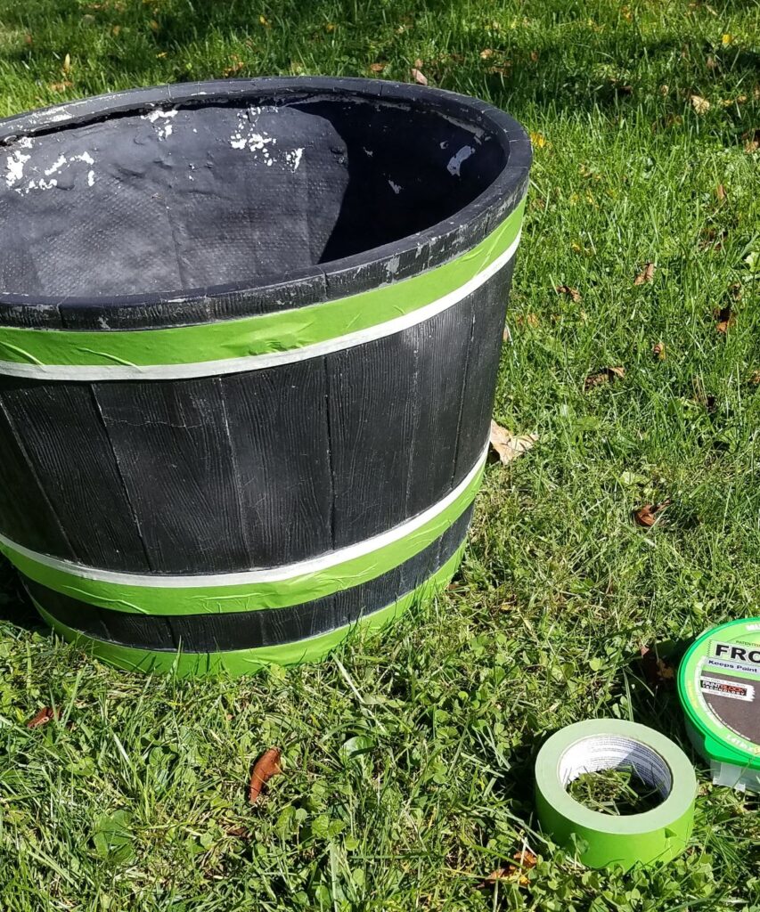 black planter with green frog tape on it