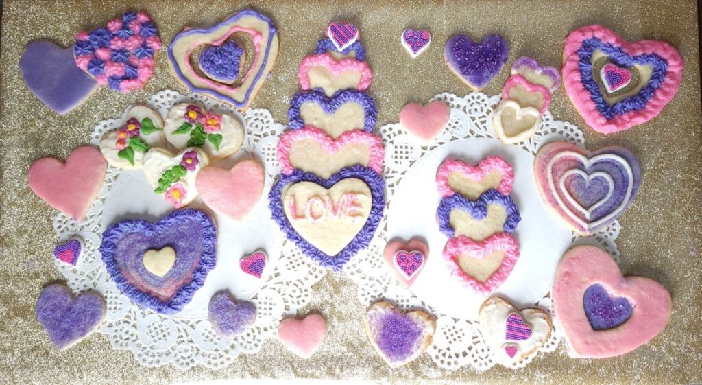 gorgeous collection of heart shaped valentine cookies in pink and purple frosting