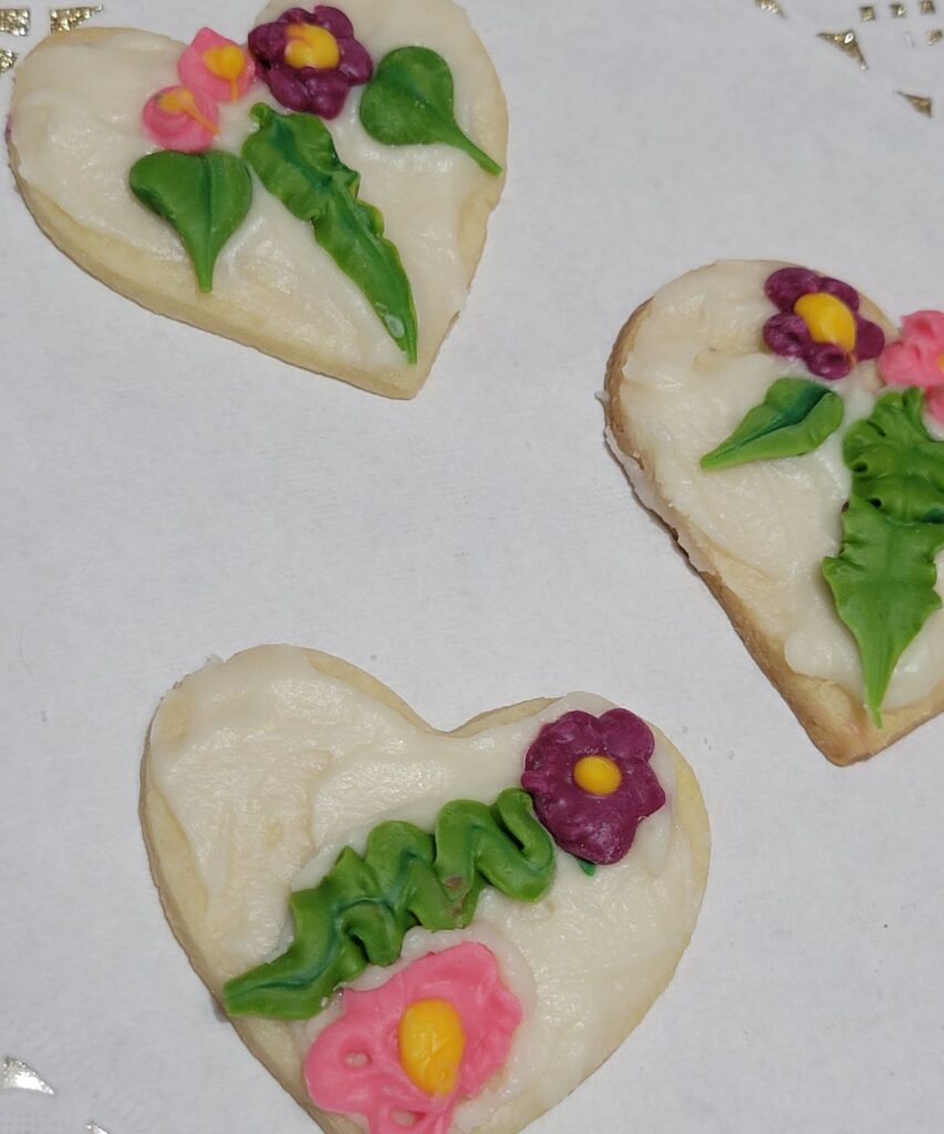 3 heart shaped cookies with flowers on them