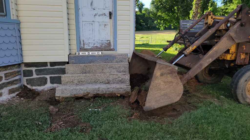 tractor bucket straightening concrete steps