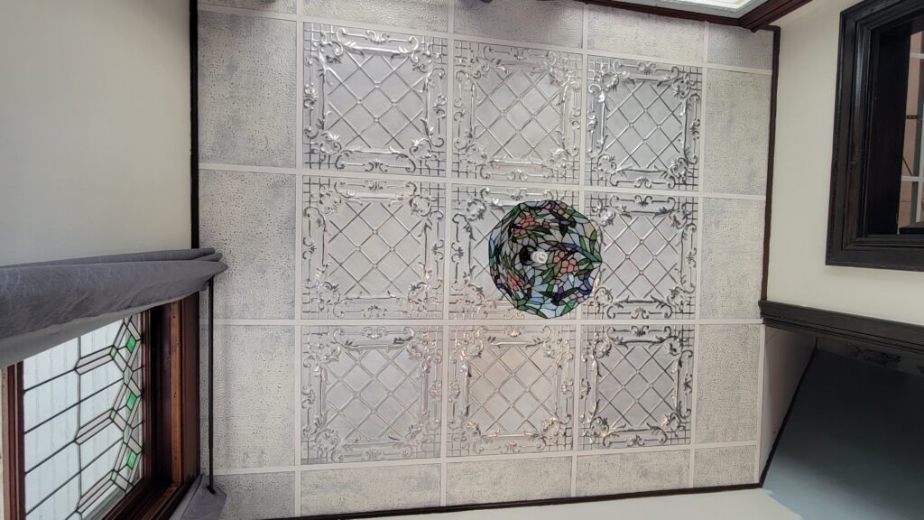 ceiling of ivory cream colored tin tiles in drop ceiling grid