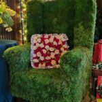 moss covered chair with flower pillow
