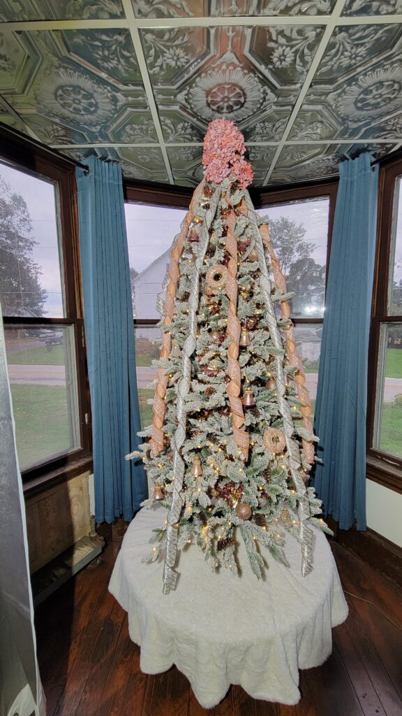 angle curtain rods on bay window with pink Christmas tree