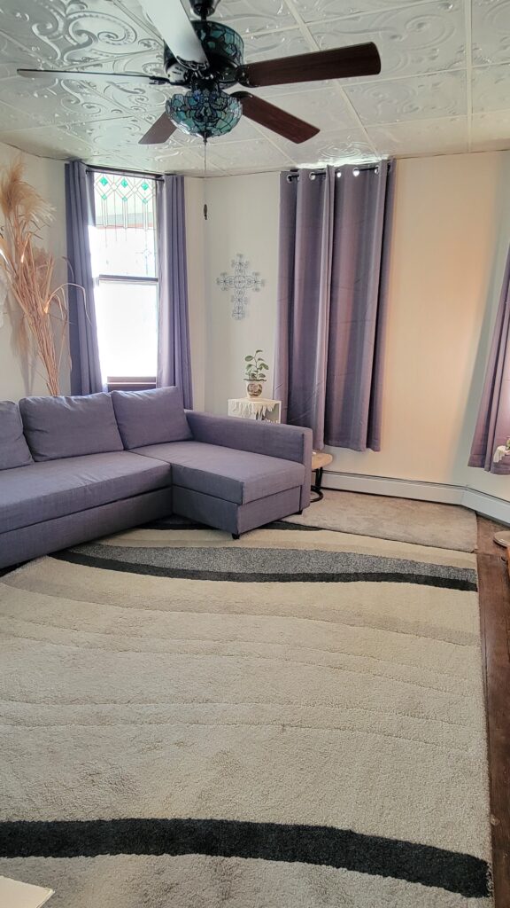 old rug in living room with gray couch